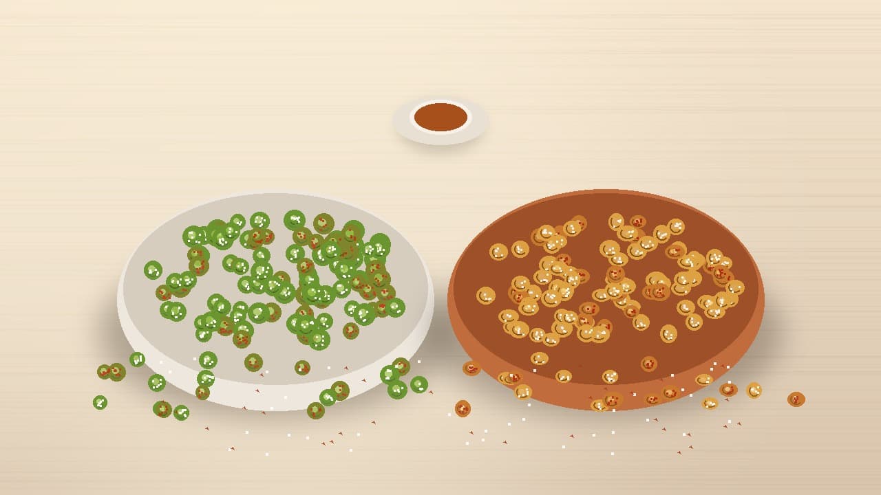 A split composition featuring a light cream ceramic bowl filled with vibrant green dry-roasted peas on the left and a warm terracotta clay bowl filled with split roasted Bengal gram (chana) on the right, set on a warm wooden tabletop with a tea companion cue.